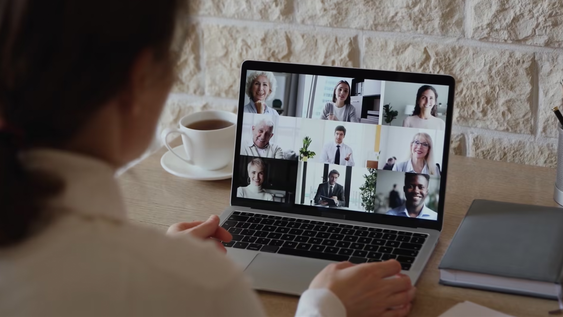 Woman talking on laptop video call with 9 people on her screen